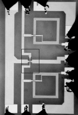 Photograph of the graphene integrated circuit showing the inductors, which are the two large square structures at the top left and right. The field effect transistor is the tiny structure at the cross in the centre of the photograph. (Courtesy: P Avouris)